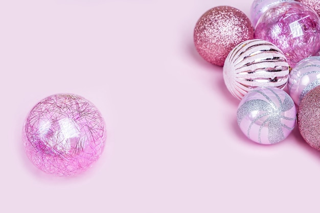 Kerst samenstelling. Set roze kerstversieringen, glanzende ballen op pastel achtergrond