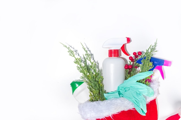 Kerst schoonmaak concept. diverse flessen, apparatuur en accessoires, handschoenen voor het reinigen met kerstdecor en kerstmuts kopieerruimte. schoonmaakservice reclame mockup achtergrond