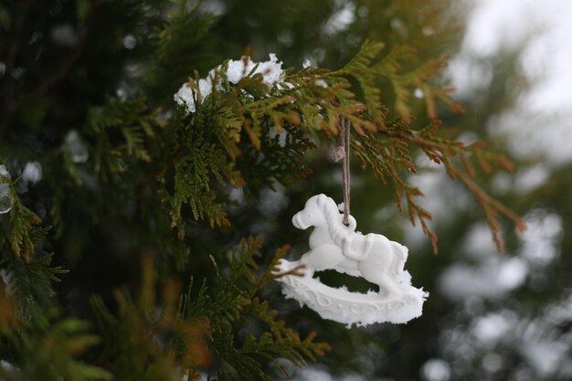 Kerst speelgoed paard opknoping op een groene takken in de sneeuw in de winter Kerstboom speelgoed paard cadeau Nieuwjaar decor