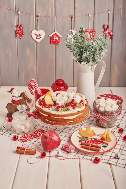 Kerst tafeldecoratie, feestelijke fruitcake met snoep op tafel