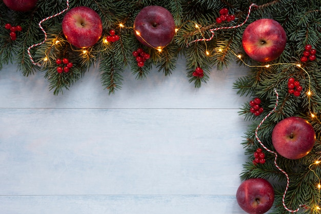 Kerst vakantie achtergrond met rode appels, rode bessen en heldere garland