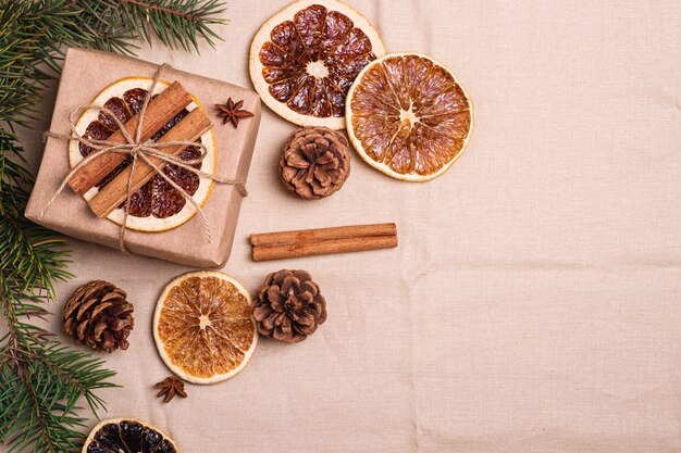 Kerst vintage compositie met handgemaakte geschenkdoos, gedroogde citrus, kaneel, kegels en dennenboom