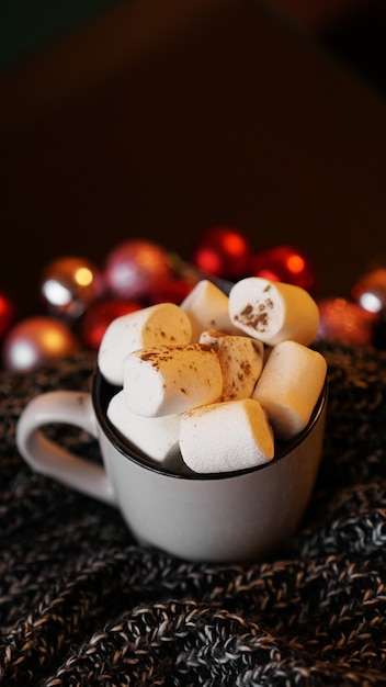 Kerst warme chocolademelk met marshmallows met licht bokeh. Selectieve focus - verticale foto