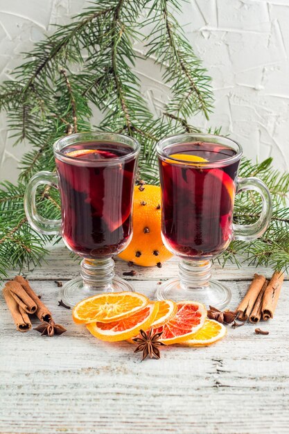 Kerst warme glühwein met kaneel sinaasappel en anijs op witte houten achtergrond met tree