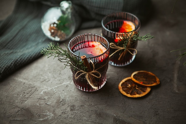 Kerst warme rode wijn met aromatische kruiden en citrusvruchten op zwarte ondergrond, close-up. traditionele warme drank in de kersttijd