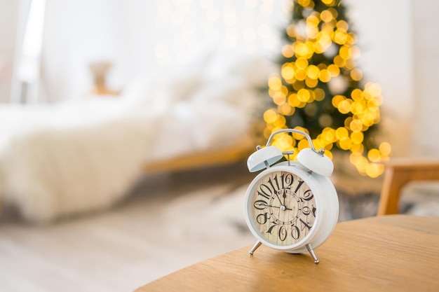 Kerst wekker op witte tafel met boken lichten. . Hoge kwaliteit foto