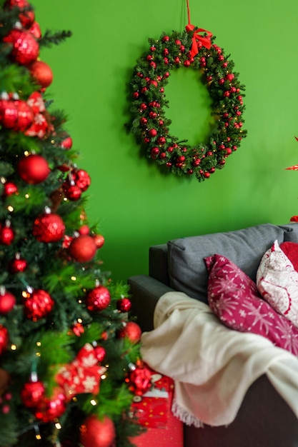 Kerst woonkamer interieur met sofa kerstboom en krans op groene achtergrond