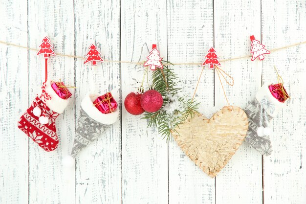 Kerstaccessoires die aan een witte houten muur hangen