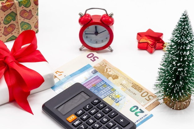 Kerstachtergrond met geschenkdozen wekker 50 en 20 euro geld en rekenmachine