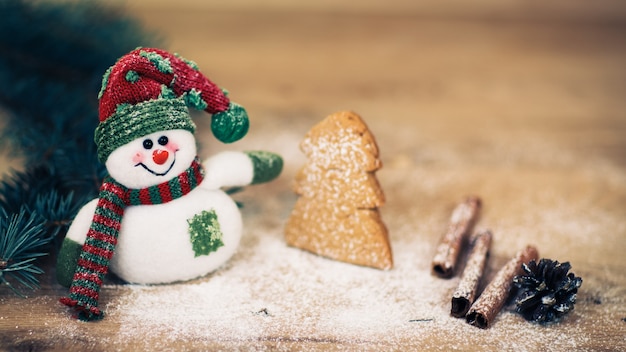 Kerstachtergrond met kerstboom en sneeuwpop op een rustieke houten plank