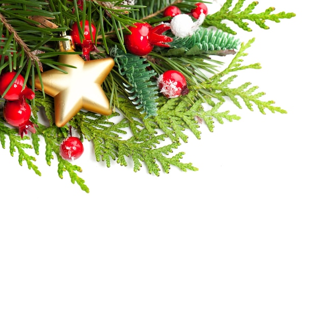 Kerstachtergrond met red holly berries, xmas tree twig en golden star op witte achtergrond met kopie ruimte