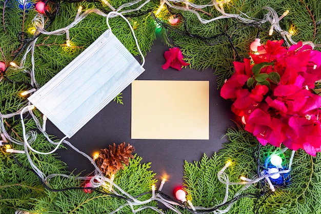 Kerstachtergrond Minimalistisch Concept Gezichtsmaskers en kerstwenskaarten met dennenbladeren