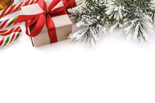 Kerstachtergrond op een witte achtergrond met cadeausnoep en sparrentak