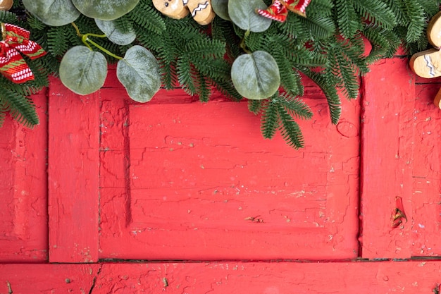 Kerstachtige achtergrond met dennenboom en nieuwjaarsversiering op rood houten bord