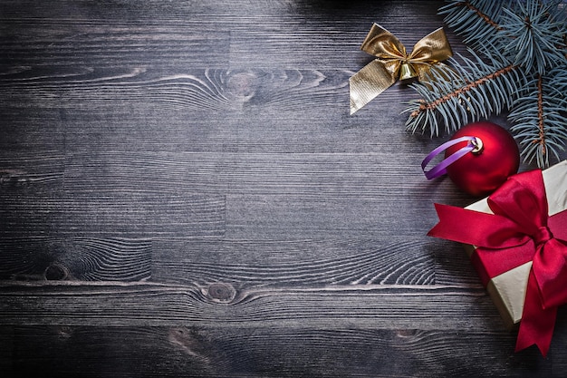 Kerstbal boog grenen takje geschenkdoos op houten bord copyspace