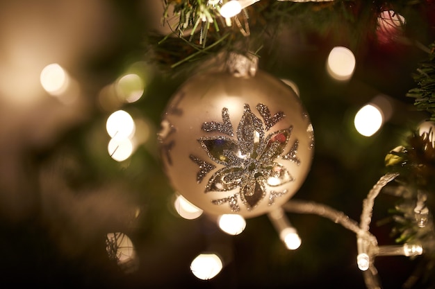 Kerstbal op kerstboom met verlichting op een achtergrond, prettige kerstdagen en gelukkig nieuwjaar