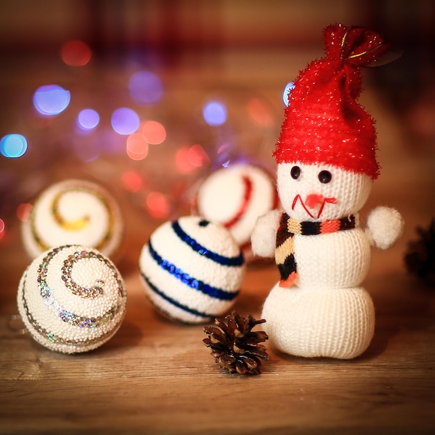 Kerstballen en een speelgoedsneeuwman op kersttafel