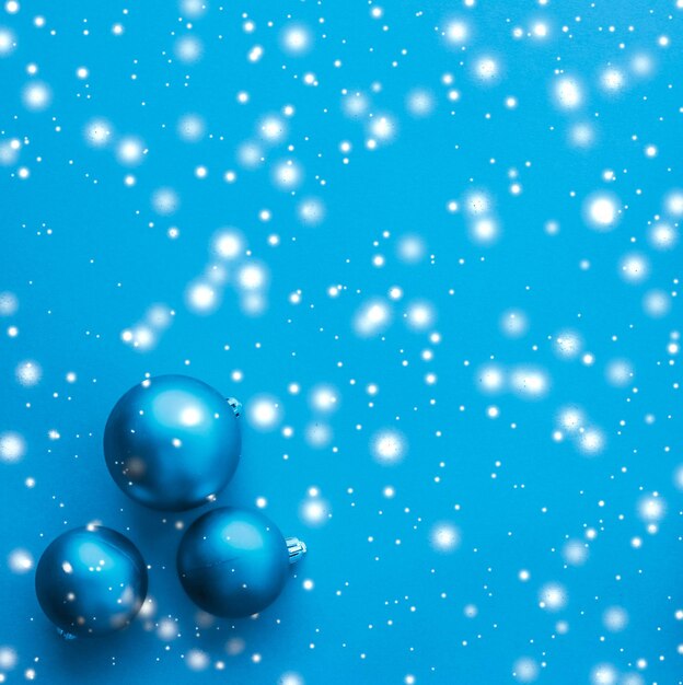 Kerstballen op blauwe achtergrond met sneeuw glitter luxe winter kerstkaart