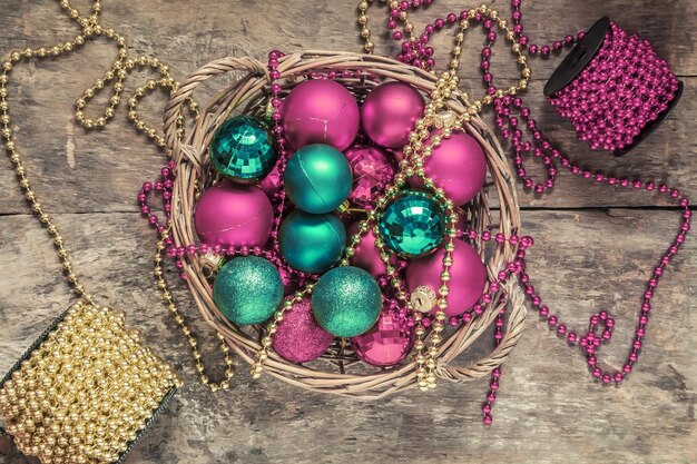 Kerstballen rood goud groene kralen liggen in een houten mand bovenaanzicht van vintage stijl