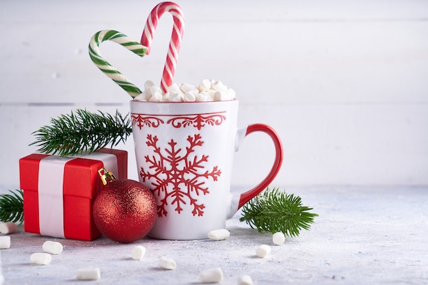 Kerstbeker met suiker cacao marshmallows en snoep. Spartakken, de doos van de Kerstmisgift op lichte achtergrondkopieerruimte.