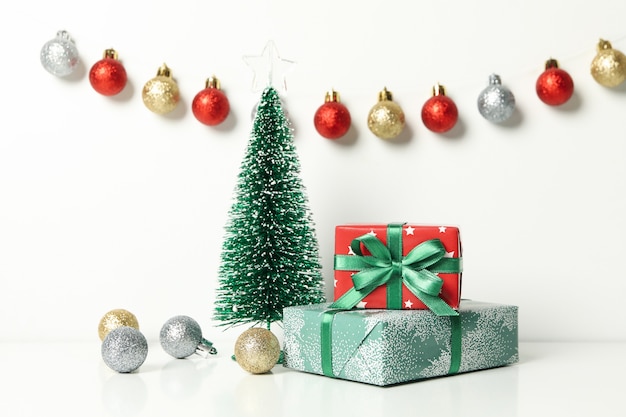 Kerstbomen, geschenken en kerstballen op witte tafel