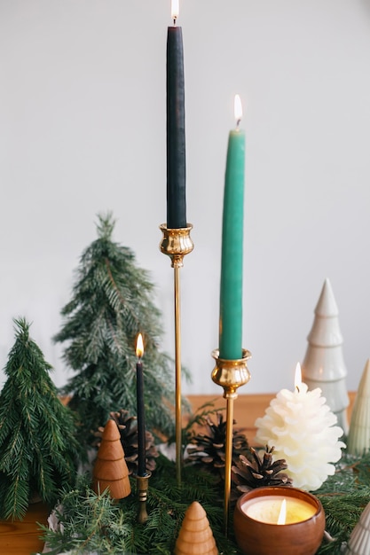 Kerstbomen kaarsen en dennenappels op rustieke stof op houten tafel Feestelijk modern decor zero waste Miniatuur houten en handgemaakte dennenbomen Prettige feestdagen