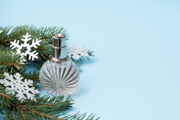 Kerstboom en fles parfumclose-up op blauw, copycopyspace