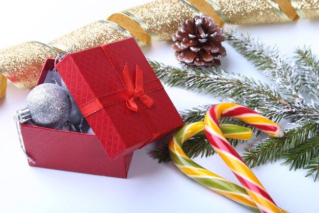 Kerstboom en kegels, de kleurrijke ballen van het nieuwjaar met lint, lollypop en giftdoos op wit. decoratie voor een fijne vakantie.