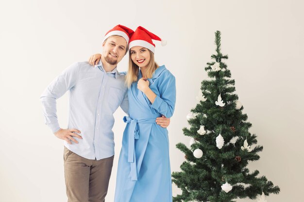 Kerstboom en vakantieconcept - Gelukkige glimlachende familie die santahoeden draagt die thuis vieren.