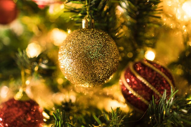 Kerstboom geassembleerd met ornamenten. Rode, zilveren en gouden ballen, geschenkdozen, lichten, de kerstman en anderen. Selectieve aandacht.