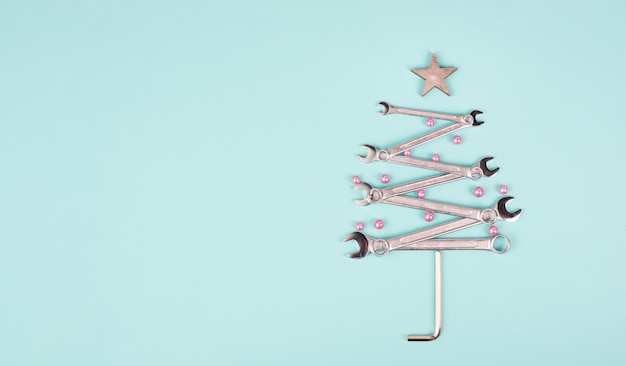 Kerstboom gemaakt met sleutels, kerstballen en een ster, nieuwjaarswenskaart met reparatietools