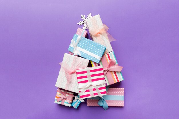 Kerstboom gemaakt van geschenkkistjes op gekleurde achtergrond nieuwjaar minimaal concept met kopieerruimte