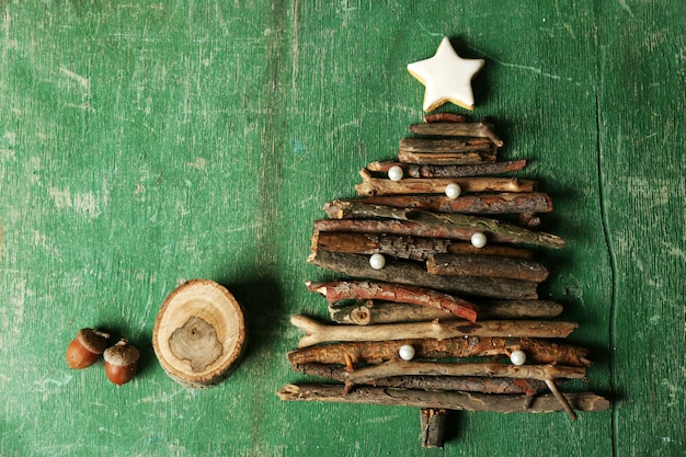 Kerstboom gemaakt van houten takken op houten tafelblad weergave