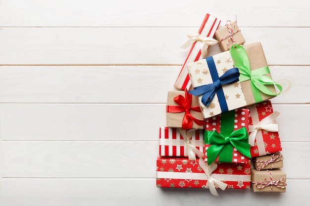 Kerstboom gemaakt van prachtig ingepakte cadeautjes op gekleurde achtergrondweergave van bovenaf Nieuwjaarsgeschenkdoos minimaal concept met kopieerruimte