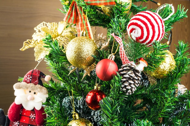 Kerstboom gemonteerd met ornamenten. Rode, zilveren en gouden ballen, geschenkdozen, lichten, de kerstman en anderen. Selectieve aandacht.