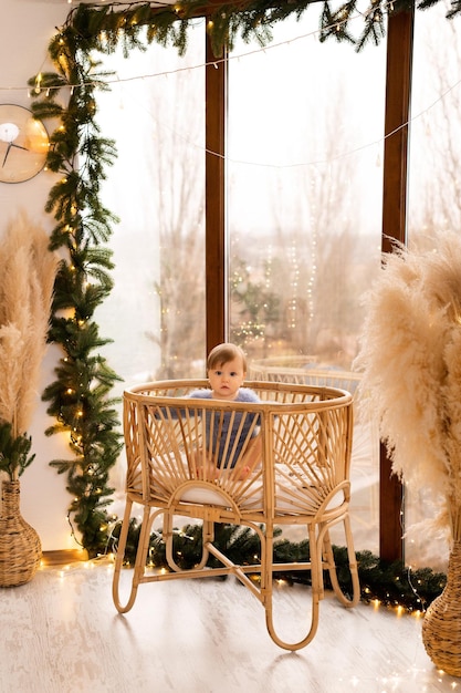 kerstboom in het huis de baby zit in de wieg bij het raam