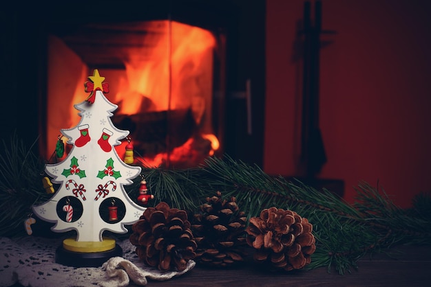 Kerstboom met kegels bij brandende open haard