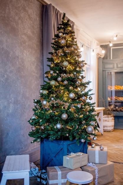 kerstboom met kleurrijke ballen en geschenkdozen in de kamer