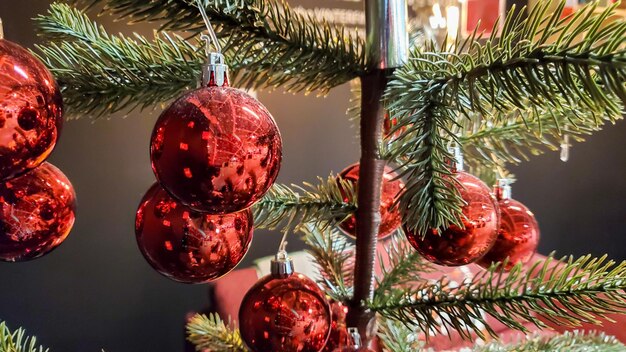 Kerstboom met rode versieringen in de woonkamer met gezellige bank en kussens