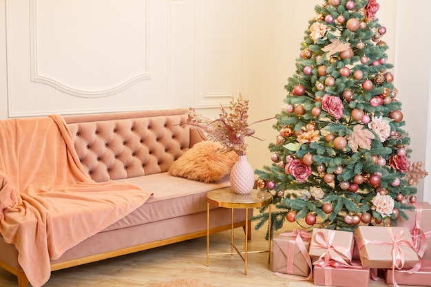 Kerstboom met roze cadeautjes in een witte kerstkamer