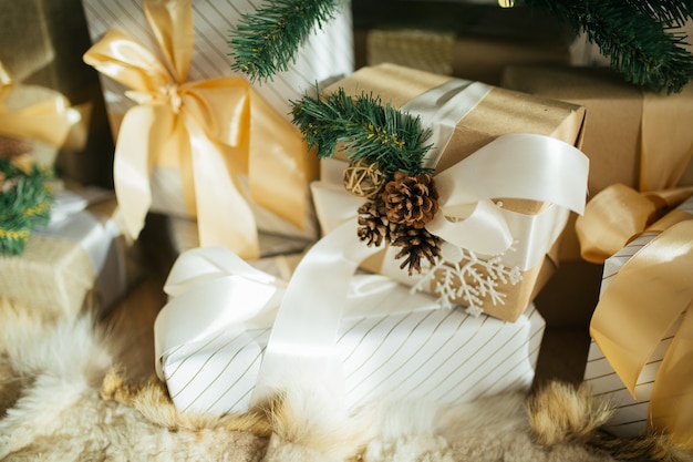 Kerstboom met rustieke decoraties, handgemaakte geschenkdozen en cadeautjes eronder in loft