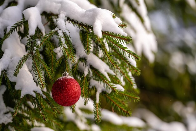 Kerstboom met sneeuw en kerstbal feestelijke winterachtergrond met bokeh