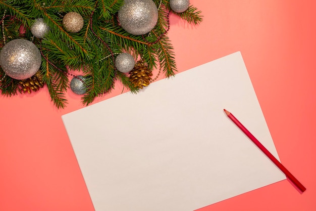 Kerstboom met versieringen met een blanco vel papier en een potlood om een kerstverlanglijstje te schrijven.