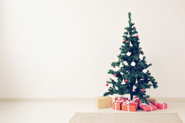 Kerstboom op de vloer tegen de muur thuis