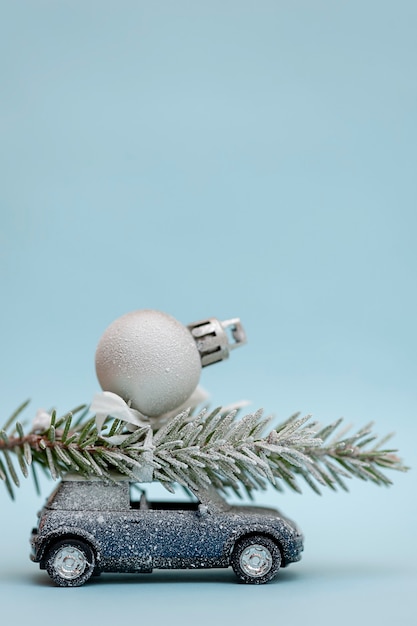 Kerstboom op een speelgoedauto op een blauwe achtergrond Verticale foto