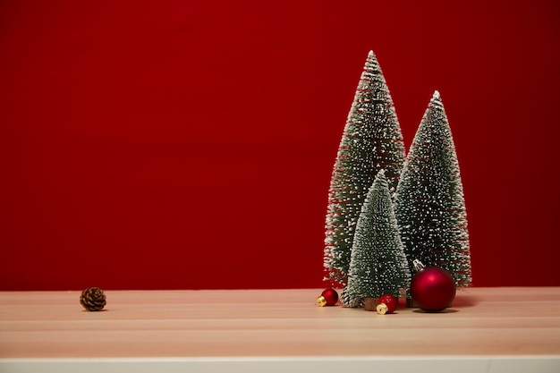 Kerstboom samenstelling geschenkdoos Kerstballen op een houten tafel muur rode achtergrond. voor nieuwjaar of vrolijk kerstfeest van vrije ruimte voor uw decoratie Kopieer ruimte voor uw tekst