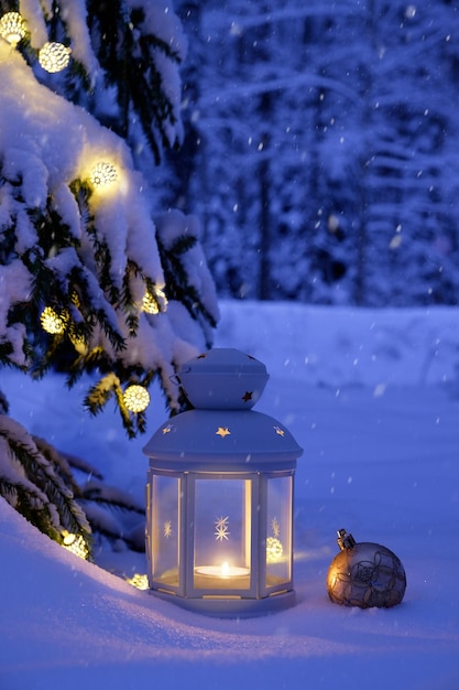 Kerstboom, slinger en lamp in het besneeuwde bos. Besneeuwd bos voor Kerstmis