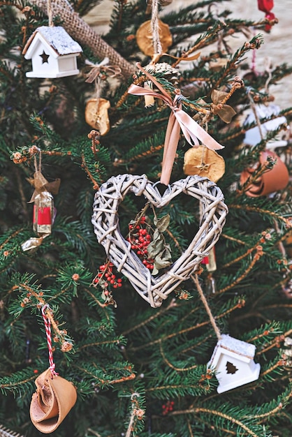 Kerstboom versierd met hartvormige geweven krans en andere handgemaakte zerowaste kerstversieringen