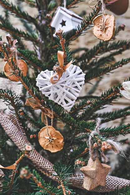 Kerstboom versierd met hartvormige rieten krans en andere handgemaakte zerowaste kerstversieringen