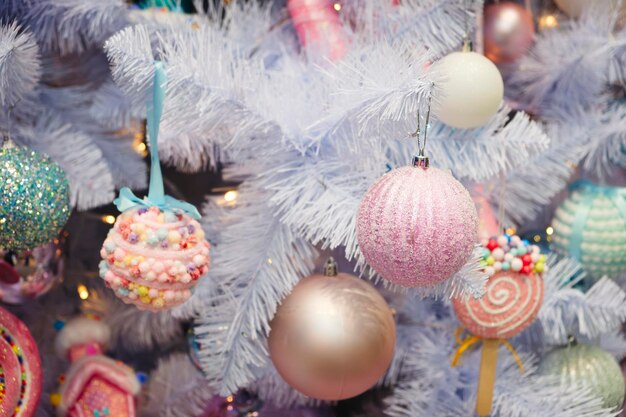 Foto kerstboom versierd met rood bal speelgoed fir tak met ballen en feestelijke lichten op de kerst achtergrond met vonken en bokeh